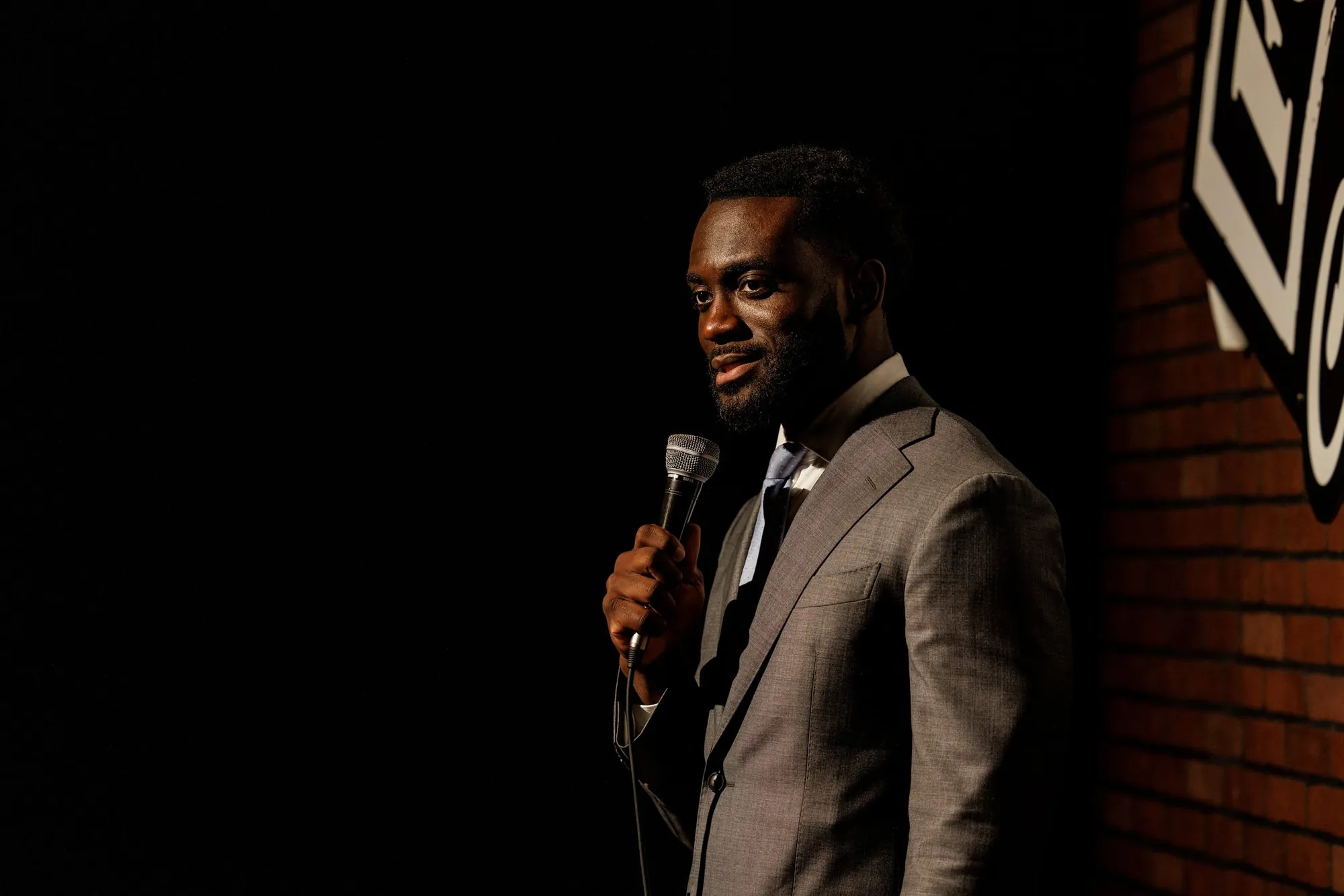 Dr. Kojo on stage in a gray suit